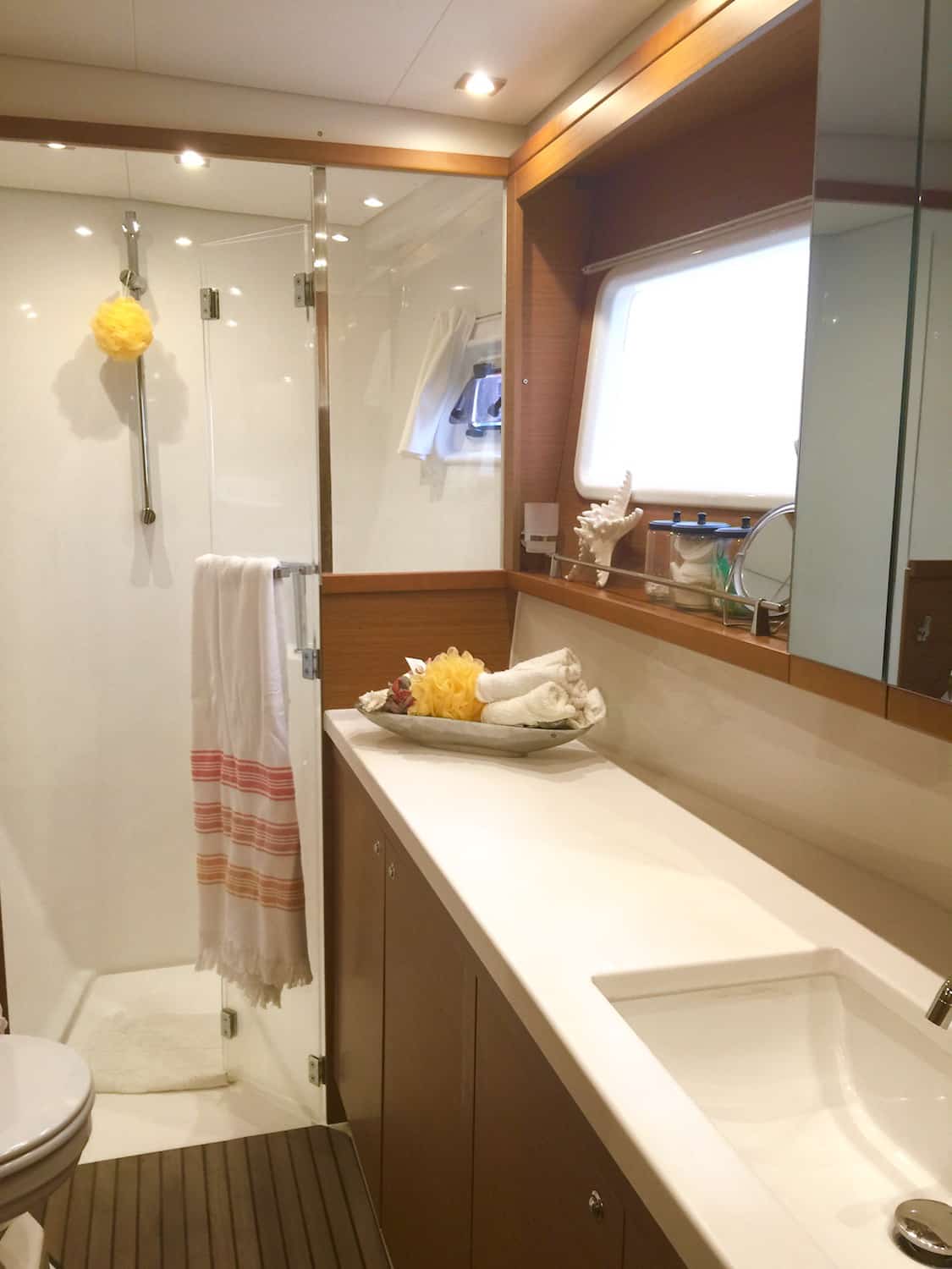 Ensuite bathroom with glass shower, vanity, and teak flooring