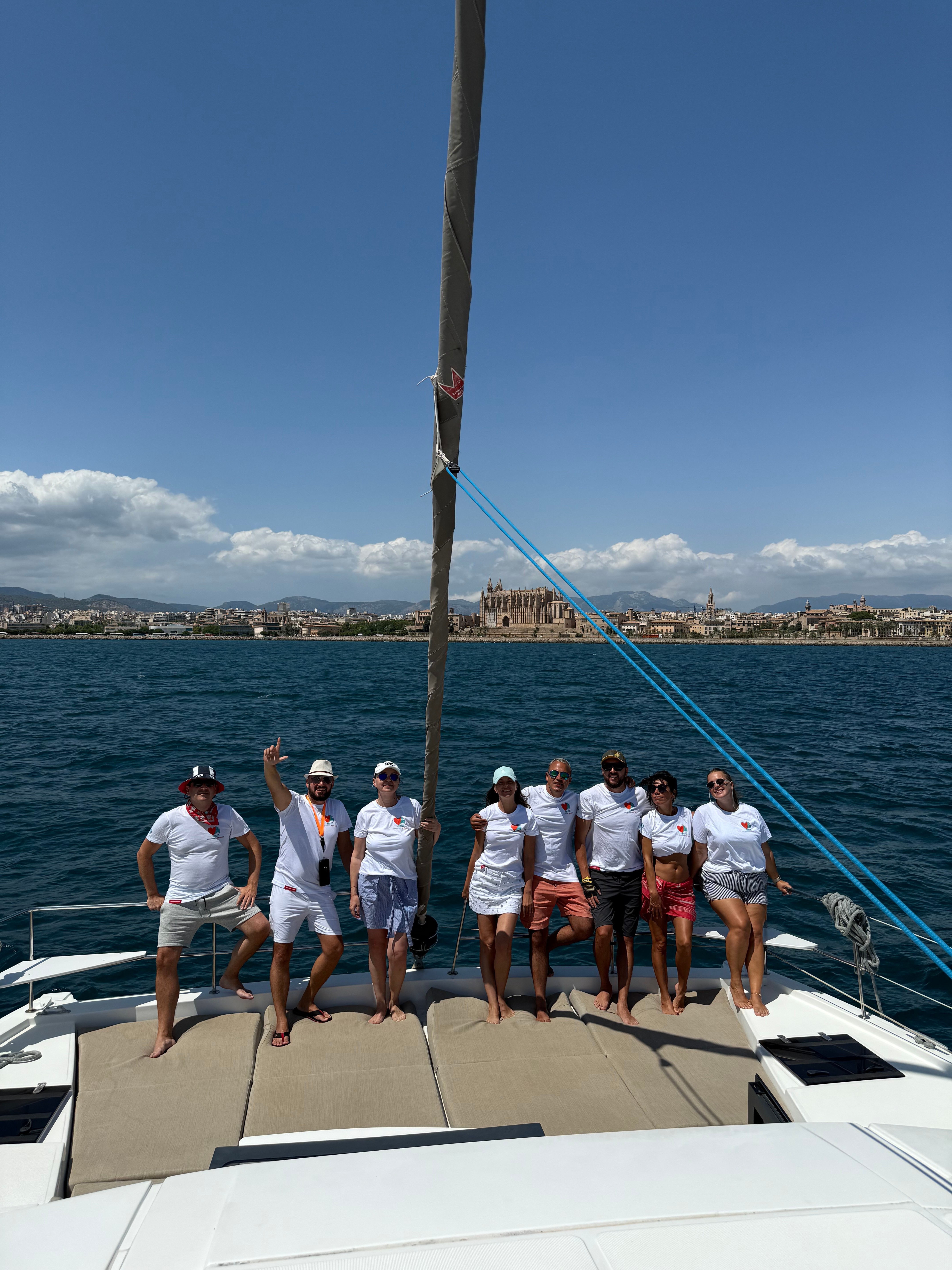 Full crew on deck with the coastline behind