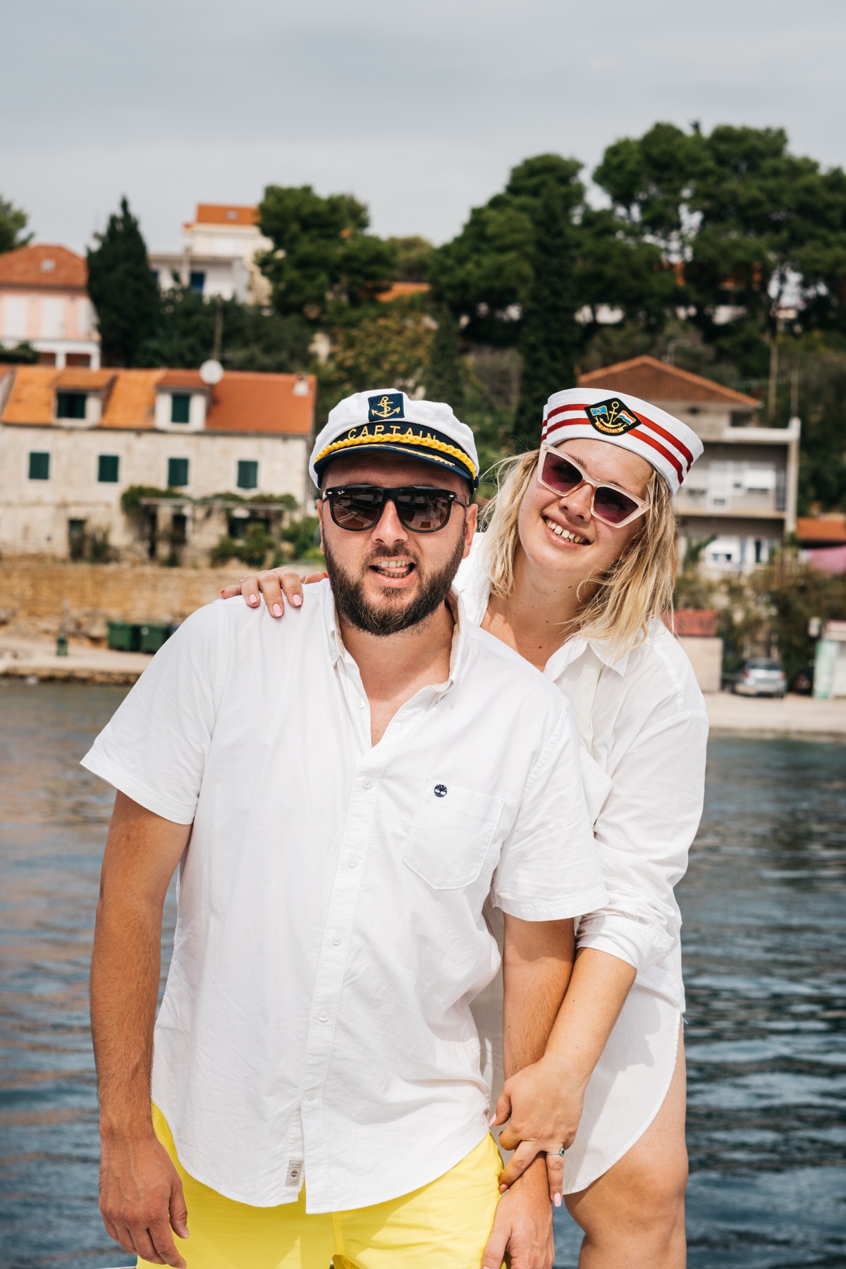 Roman and Ana with captain hats, smiling on the waterfront