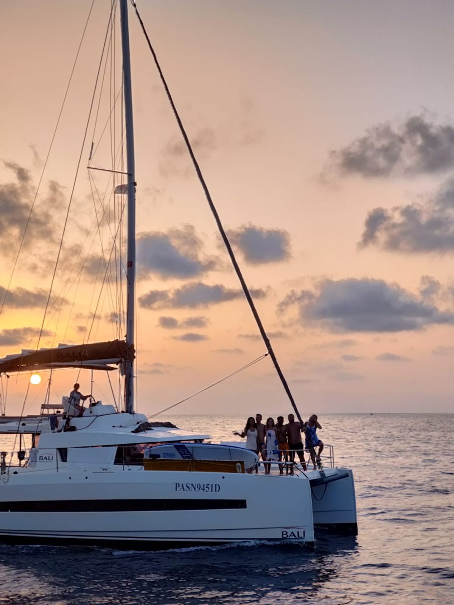 Crew gathered on the catamaran bow at sunrise